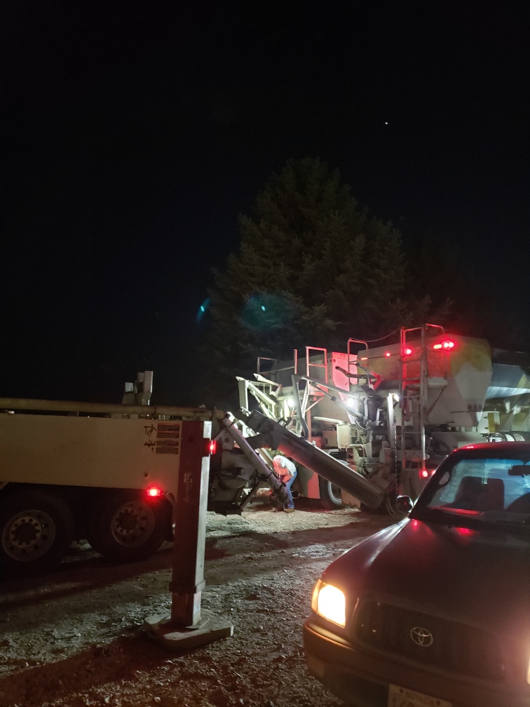 Concrete trucks discharging into concrete pump.